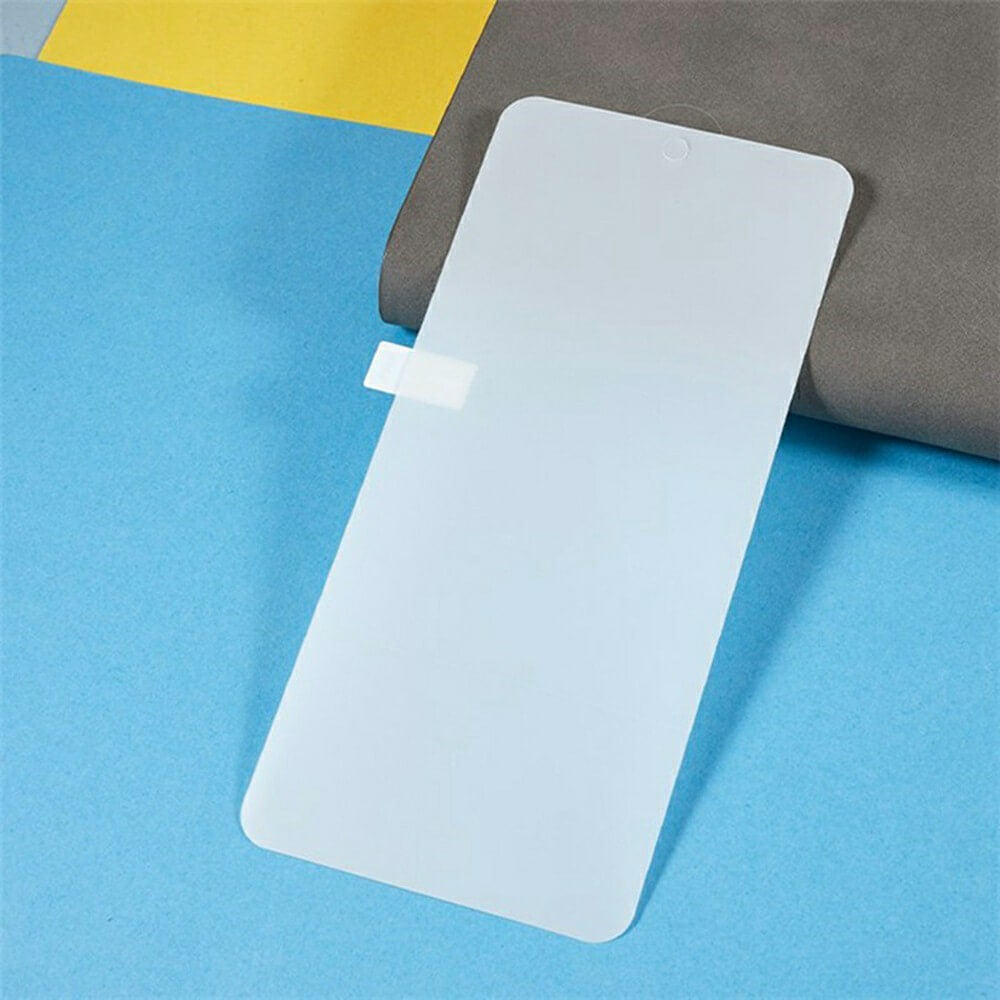 Transparenter Displayschutz mit abgerundeten Ecken, auf grauem Stoff vor blau-gelbem Hintergrund.