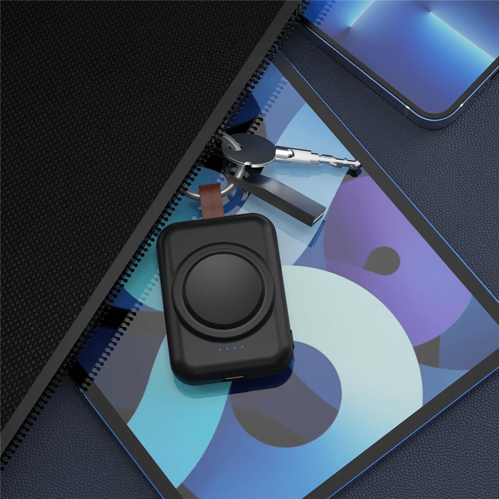 Schwarzes kabelloses Ladegerät für kabelloses Laden, Schlüssel und Tablet mit einem bunten Bildschirm auf einer dunklen Oberfläche. Kommt mit dem Cover-Discount.ch Mini Powerbank Samsung Galaxy Watch 1800mAh für zusätzlichen Komfort.