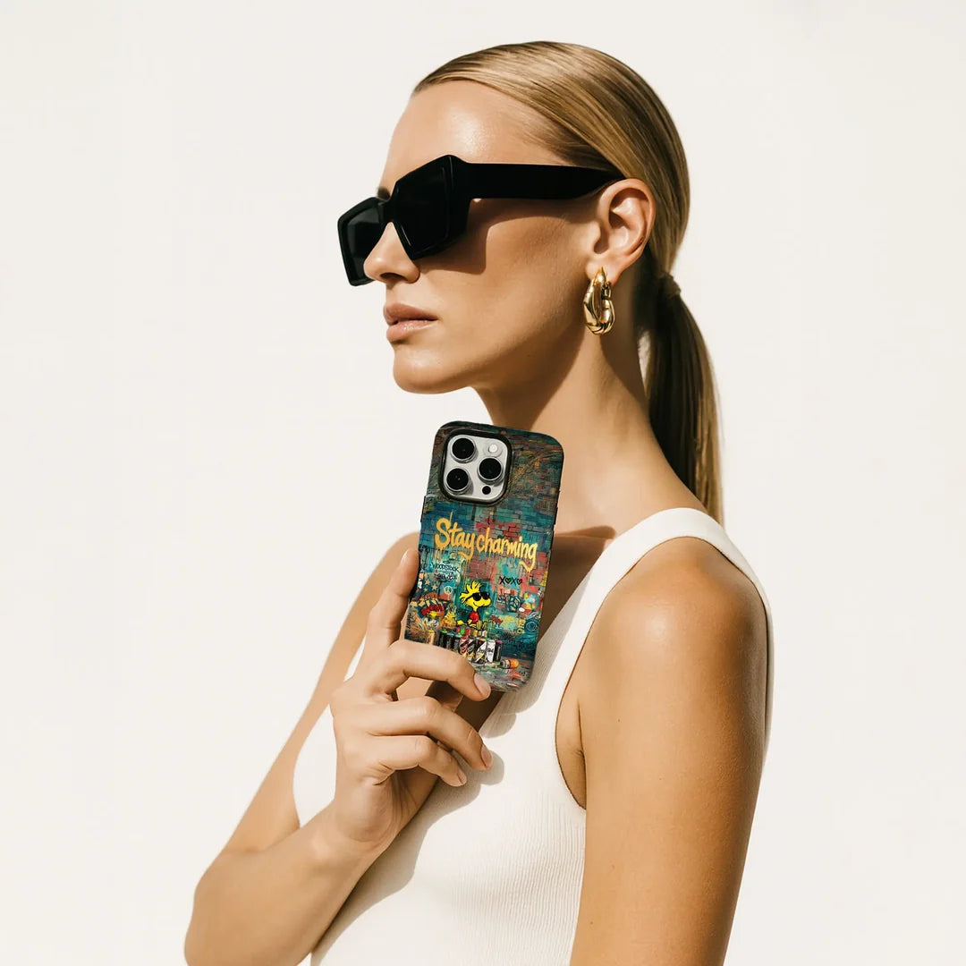Eine Frau mit Sonnenbrille, die eine Cover-Discount-Hülle für das iPhone 18 Pro Max Cool Bird mit MagSafe-Funktion in der Hand hält.
