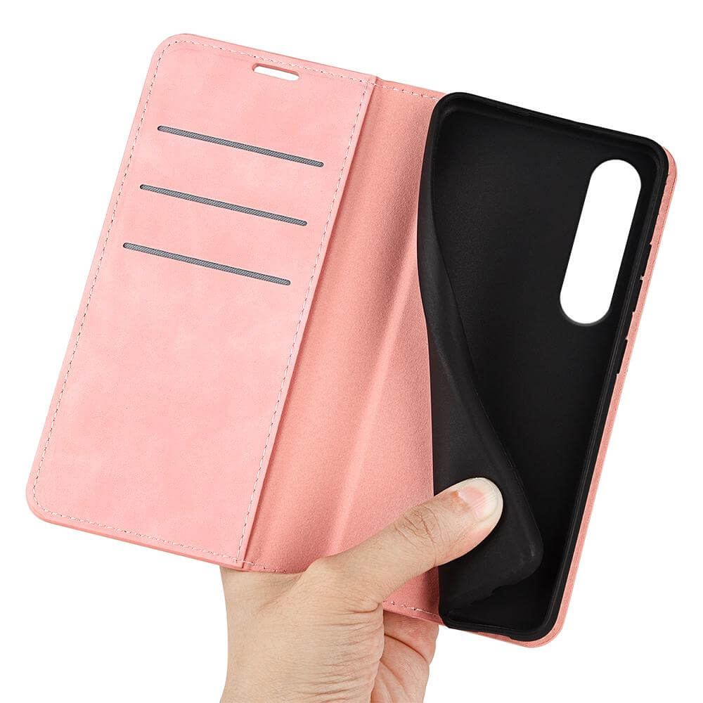 Eine Hand hält das Cover-Discount Sony Xperia 1 VII Stand Flip Case Hülle, eine rosafarbene Brieftaschenhülle mit Kartenfächern, flexiblem schwarzem Ständer und Handyhülle-Design.